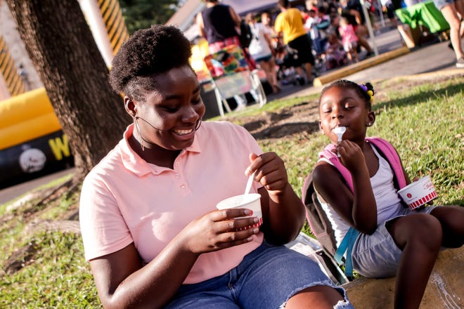Tyonna Wright and Naisia Sinclair have frozen custard during National Night Out held at Tera Gardens where the neighborhood gathers for a block party on Tuesday, August 7, 2018. [Raul F. Rubiera/The Fayetteville Observer]