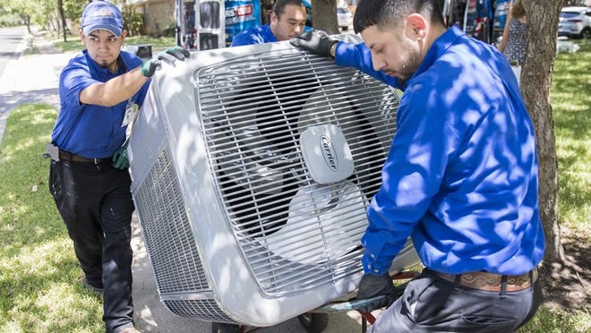 ARS/Rescue Rooter Edgar Gutierrez , Pablo Hernandez Jr. and Jose Gutierrez move a new HVAC unit into David Cosner’s home in South Austin on Wednesday. RICARDO B. BRAZZIELL / AMERICAN-STATESMAN