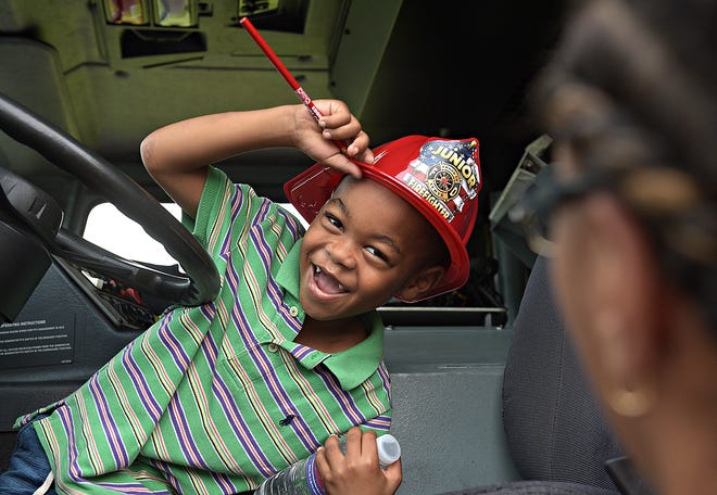 JR Adetutu, of Bensalem, sits in a firetruck during National Night Out in Bensalem on Tuesday. [KIM WEIMER / STAFF PHOTOJOURNALIST]