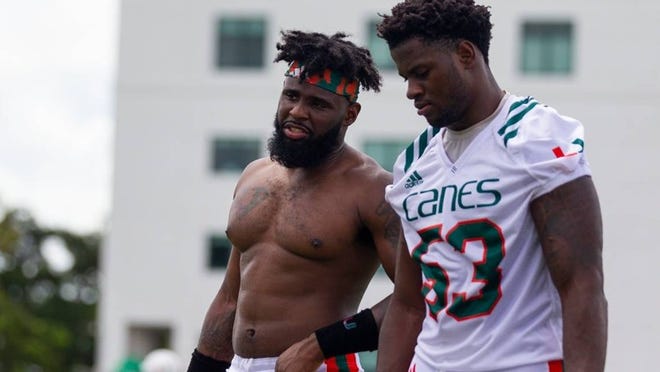 Hurricanes linebacker Michael Pinckney (56) talks to his teammate Zach McCloud (53) after the first day of fall training camp at the Greentree Practice Fields in Coral Gables on Saturday, August 4, 2018.