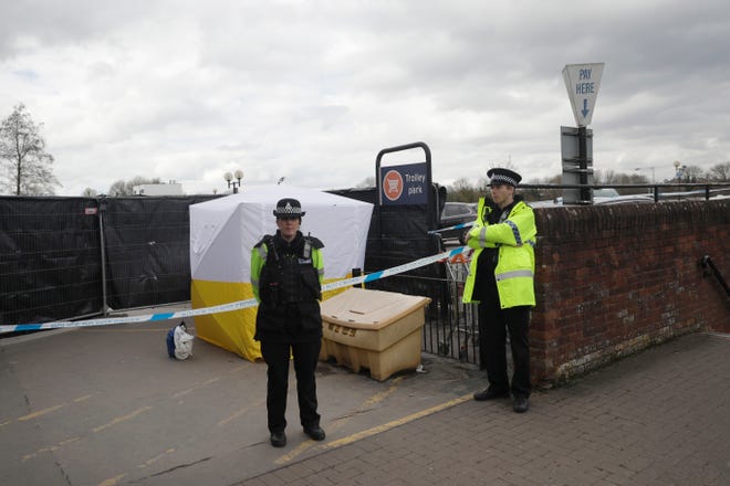 FILE - In this March 13, 2018, file photo, police officers guard a cordon around a police tent covering a supermarket car park pay machine near the spot where former Russian spy Sergei Skripal and his daughter were found critically ill following exposure to the Russian-developed nerve agent Novichok in Salisbury, England. The United States will impose sanctions on Russia for the country’s use of a nerve agent in an assassination attempt on a former Russian spy and his daughter. The State Department says Aug. 8, sanctions will be imposed on Russia as the country used chemical or biological weapons in violation of international law.(AP Photo/Matt Dunham, File)