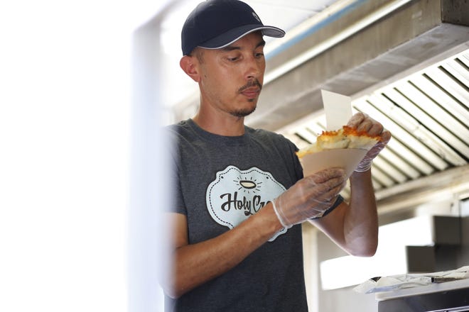 FILE - Saphir Grici, owner of the Holy Crepe food truck, gets ready to hand off a freshly made crepe during the June food truck night at the Jittery Joe's roaster in Athens, Ga [Photo/Joshua L. Jones, Athens Banner-Herald]