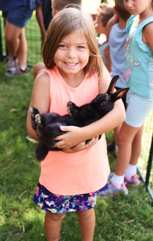 Zoe Humphrey holds a bunny from Buffalo Mobile Petting Zoo during Oklahoma City Indian Clinic's Children's Health Fair. [PHOTO PROVIDED]