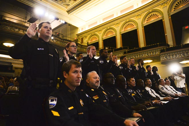 Savannah police cadets take their oaths of office on Friday at the Lucas Theatre during a badge-pinning ceremony. 17 new officers joined the force on Friday. [Will Peebles/Savannahnow.com]