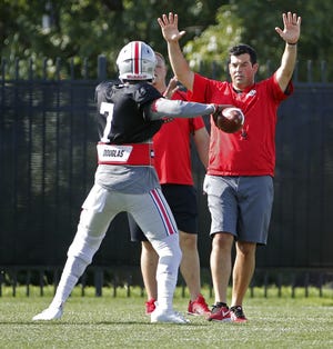 Ryan Day, promoted to acting head coach with Urban Meyer placed on leave, works with Ohio State starting quarterback Dwayne Haskins Jr. during a recent practice. [Kyle Robertson/Dispatch]