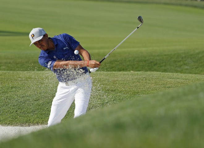 Rickie Fowler hits out of a bunker to the 18th green during the second round of the PGA Championship on Saturday at Bellerive Country Club in St. Louis. [JEFF ROBERSON/THE ASSOCIATED PRESS]