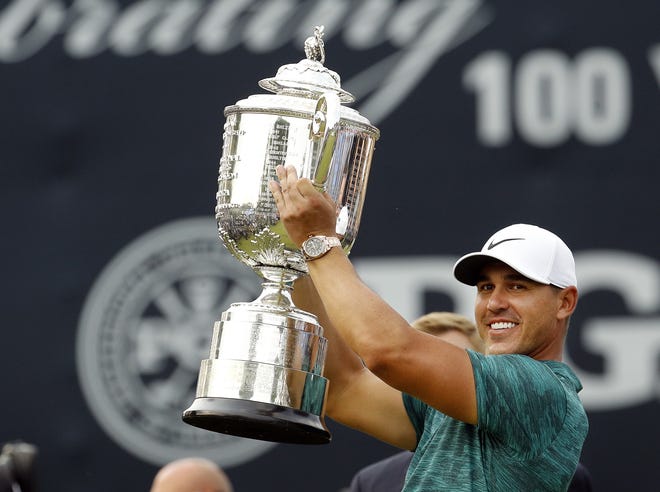 Brooks Koepka lifts the Wanamaker Trophy after winning the PGA Championship at Bellerive Country Club on Sunday in St. Louis. [AP Photo/Charlie Riedel]
