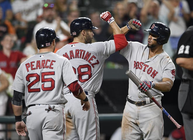 Red Sox's J.D. Martinez, center, celebrates his two-run home run with Xander Bogaerts, right, and Steve Pearce during the eighth inning of Saturday's nightcap against the Orioles. [Nick Wass/The Associated Press]