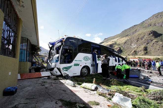 Police and rescue workers work on a Colombian-registered bus traveling to Quito, that crashed in Pifo, Ecuador, on Tuesday. At least 24 people were killed and another 19 injured when a bus careened into another vehicle at high speed and overturned along the Pifo-Papallacta highway, near Ecuador's capital, local officials reported.