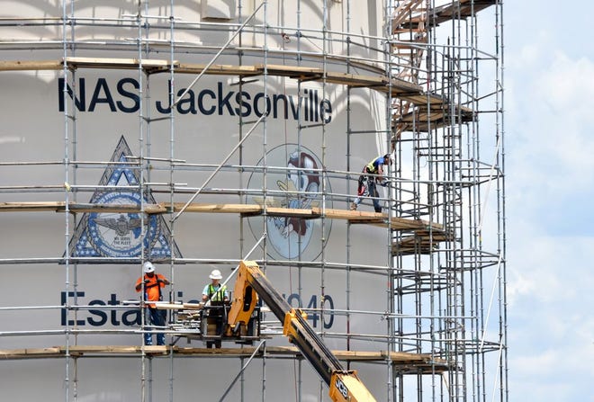 Workers set up scaffolding around a tank at the Fuel Farm aboard Naval Air Station Jacksonville Aug. 3. The tank will be repainted and maintenance will be done to the interior and exterior of the structure. Work is expected to be competed in December.