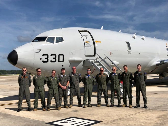 Photo by Lt. Darryl Abriam 
Royal Australian Air Force aircrew and instructors gather in front of a P-8A Poseidon aircraft at Patron Squadron 30. The team recently completed training in the new aircraft.
