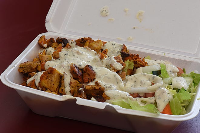 Grilled chicken over rice with a salad is topped with a creamy dill sauce at New York Platter. [Herald News Photo | Jack Foley]