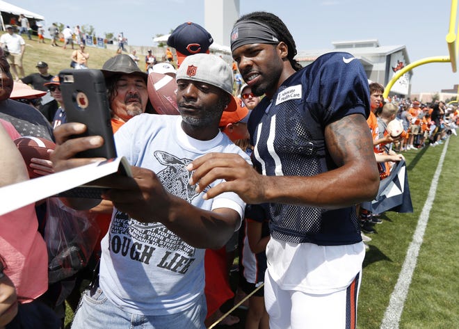Chicago Bears wide receiver Kevin White, right, poses for a photograph with a fan as White signs autographs after drills during a joint training camp session with the Denver Broncos Wednesday, Aug. 15, 2018, at Broncos' headquarters in Englewood, Colo. [DAVID ZALUBOWSKI/THE ASSOCIATED PRESS]