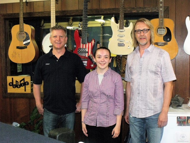 Tony Harrison, left, with employee Kiya Hattaway and Jeff Stone. The Cape Fear Music Center sells, rents and repairs instruments, and provides music lessons six days a week. [Alison Minard for The Fayetteville Observer]