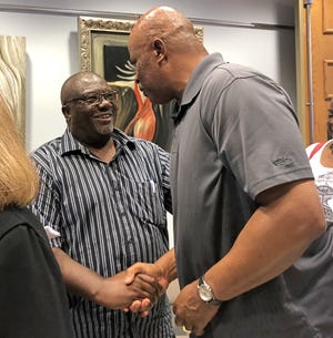 Tavares Pastor Mike Watkins, left, shakes hands with a supporter after City Council members said that because Gen. Edmund Kirby Smith had no ties to Lake County — or Tavares — the statue does not belong in the museum. [Roxanne Brown/Daily Commercial]