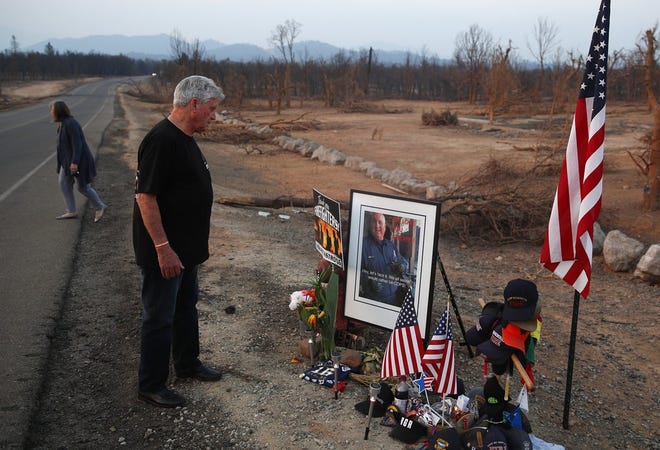 Gary Parmely, father of Jeremy Stoke of the Redding Fire Department, visits a memorial for his son in Redding, Calif. Officials say Stoke, the first firefighter to die battling a Northern California blaze, was killed by a fire tornado. [AP Photo/John Locher]