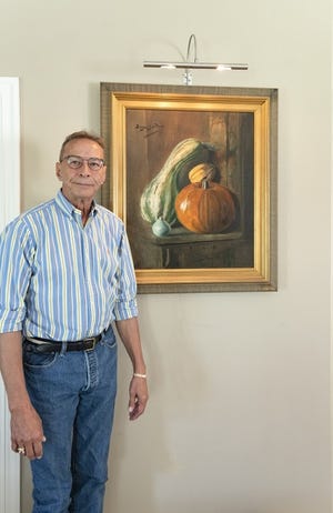 Auction Organizer Christopher Britton is pictured with a rare 1894 Birger Sandzen still life oil on canvas titled "Pumpkin & Squash." [Courtesy]