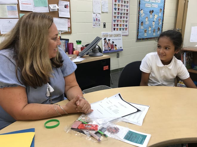 Graduation Enhancement Technician Jane Steininger speaks with Jocelyn, a third-grade student at Palmetto Elementary School, about the importance of getting to school on time. [Herald-Tribune staff photo / Ryan McKinnon]