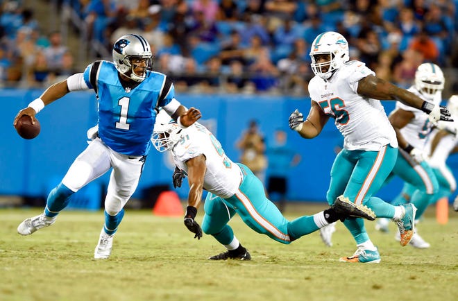 Carolina Panthers' Cam Newton (1) scrambles away from Miami Dolphins' Cameron Wake (91) and Davon Godchaux (56) in the first half of a preseason NFL football game in Charlotte, N.C., Friday, Aug. 17, 2018. (AP Photo/Mike McCarn)