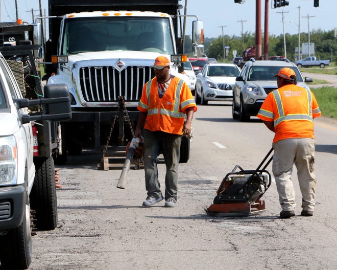 A road crew with the Arkansas Department of Transportation works to fill potholes Thursday, Aug. 16, 2018, in the northbound lanes of U.S. 71 after heavy rains passed through the area. The department is tasked with all maintenance of state highways inside the Fort Smith city limits. [JAMIE MITCHELL/TIMES RECORD]