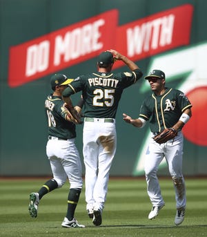 From left, Oakland Athletics' Chad Pinder, Stephen Piscotty (25) and Ramon Laureano celebrate a win over the Houston Astros at the end of a baseball game Saturday in Oakland, Calif. [AP Photo/Ben Margot]