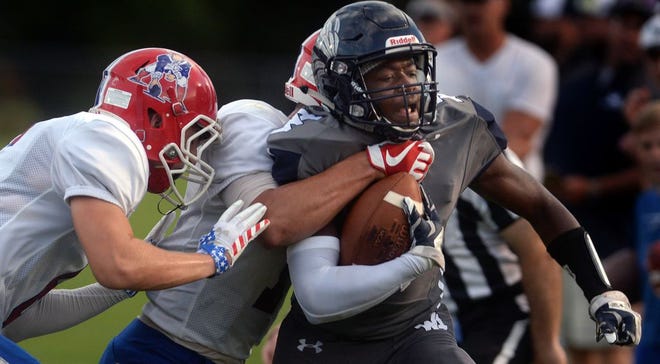 Western Alamance's Tre Sharpe is tackled by the defense of Southern Alamance's Jacob Freeze, left, and Bryce Easter.