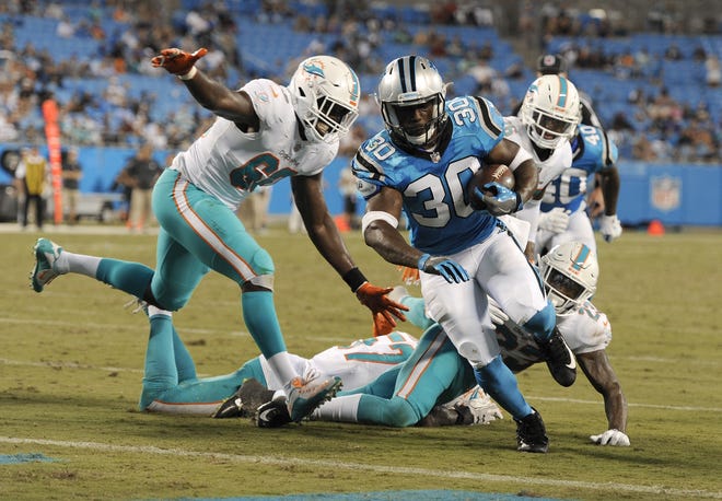 Carolina's Elijah Hood (30) runs past Miami's Claudy Mathieu (60) for a touchdown in the second half of a preseason game in Charlotte, N.C., on Friday. [AP Photo/Mike McCarn]