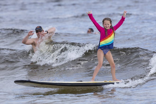 Anna Harris, 10, learn to surf near M.B. Miller County Pier on Saturday. Autism Surfs PCB hopes to give children with autism a confidence boost and place for typical children to play with their autistic friends and family. [JOSHUA BOUCHER/THE NEWS HERALD]
