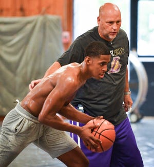 RON JOHNSON/JOURNAL STAR Former Manual basketball star Adam Miller, now point guard for Chicago Morgan Park, works with personal basketball trainer David Williams at the Hanna City Park District gymnasium on Thursday, Aug.16, 2018.