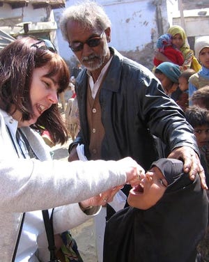 Rotarian Lynn Freshman administers the polio vaccine to a child in India. [PHOTO PROVIDED/DAVE LUITWEILER]