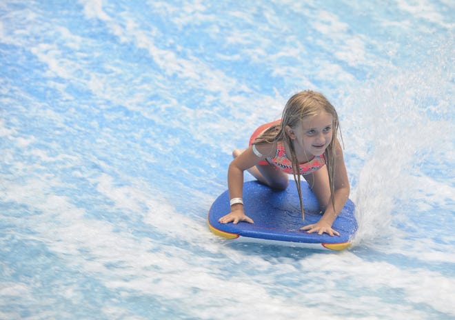 Katelyn O'Rourke, 6, of Farmingdale, NY, tries out the FlowRider at Camelback Resort's Aquatopia water park on Monday. O'Rourke was at the Park with her family and 185 others for their Salute to the FDNY event which brought families affected by the events of 9/11 to the park for a day of fun. [KEITH R. STEVENSON/POCONO RECORD]