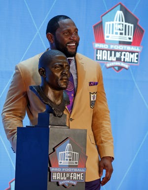 Former NFL player Ray Lewis poses with a bust of himself during an induction ceremony at the Pro Football Hall of Fame on Aug. 4 in Canton, Ohio. [RON SCHWANE/THE ASSOCIATED PRESS]