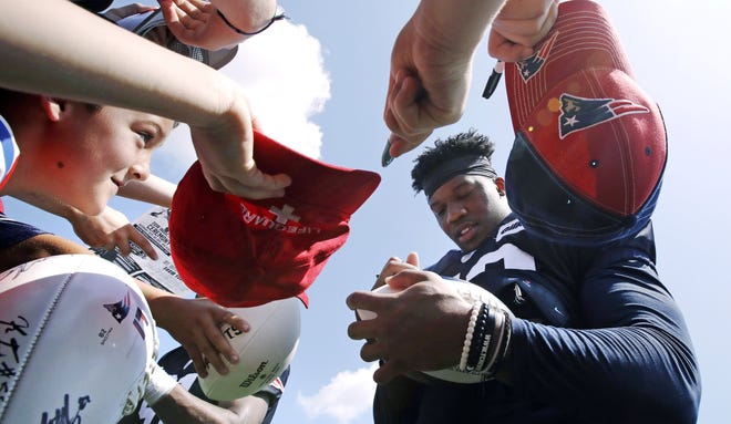 Patriots defensive end Keionta Davis, pictured signing autographs for fans during training camp on July 27, is hoping to earn his way on to New England's 53-man roster once the preseason comes to a close. [AP Photo/Charles Krupa]