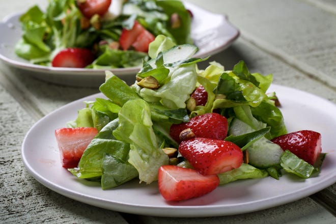 A tender green salad is topped with strawberries, cucumber, pistachio and basil. [Deb Lindsey / The Washington Post]