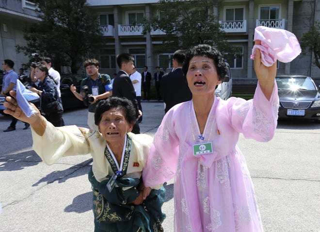 North Korean Ko Jung Hi, 77, left, and Ri Kyong Sun, 53, wave to their South Korean relatives leaving by bus after the separated family reunion meeting at the Diamond Mountain resort in North Korea on Wednesday. [Korea Pool Photo via AP]