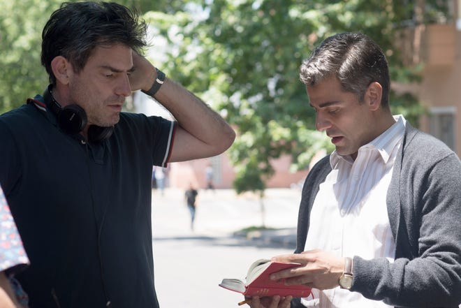 Chris Weitz (left) goes over a scene from “Operation Finale” with star Oscar Isaac. [MGM Pictures]