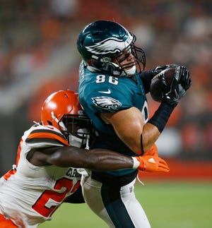 Eagles tight end Zach Ertz catches a pass under pressure from Browns defensive back Jabrill Peppers during Thursday's game. [Ron Schwane/The Associated Press]