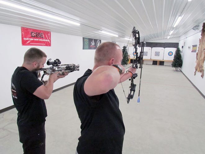 Joe Renshaw and Lance Hasten use the indoor archery range at Broadheads & Bullets.