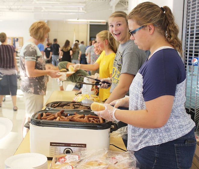 FFA members serve hamburgers and hot dogs to students and their parents during Prairie Central High School’s first freshmen cookout event. Serving food at right, from front to back, are Rachel McGreal, Autumn Bolen and Kelsey Edelman.