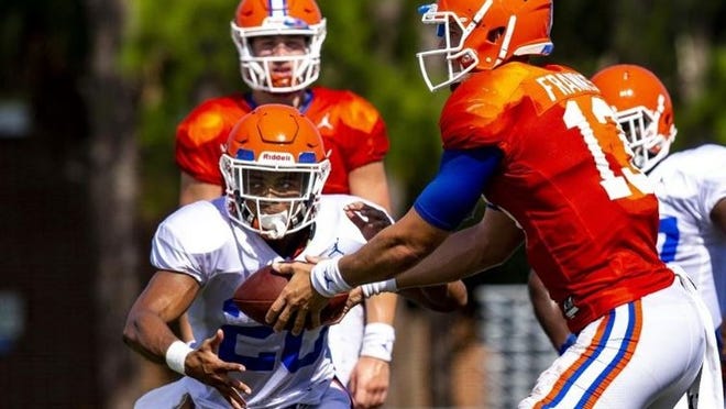 Florida quarterback Feleipe Franks hands the ball off to running back Malik Davis during a practice earlier this month. (Lauren Bacho/The Gainesville Sun)