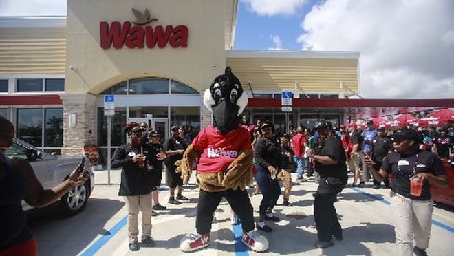 Wawa mascot Wally danced with employees during the grand opening of the Wawa on Belvedere Road on June 15, 2017. The Wawa was part of a larger development to include Del Taco restaurant, a self-storage warehouse and a hotel. (Bruce R. Bennett / The Palm Beach Post)