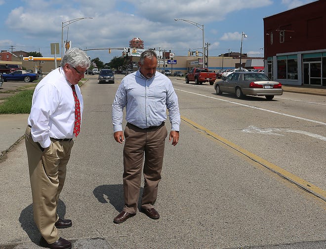 New Philadelphia Mayor Joel Day and Service Director Ron McAbier look over some of the bad spots on S. Broadway that the paving project will take care of when finished. (TimesReporter.com / Jim Cummings)