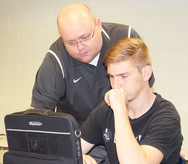 Freshman Damian Wilmoth receives help with his assignment from English teacher Brian Blair. Emphasis is being placed on improving teacher-student communication this year at Pontiac Township High School.