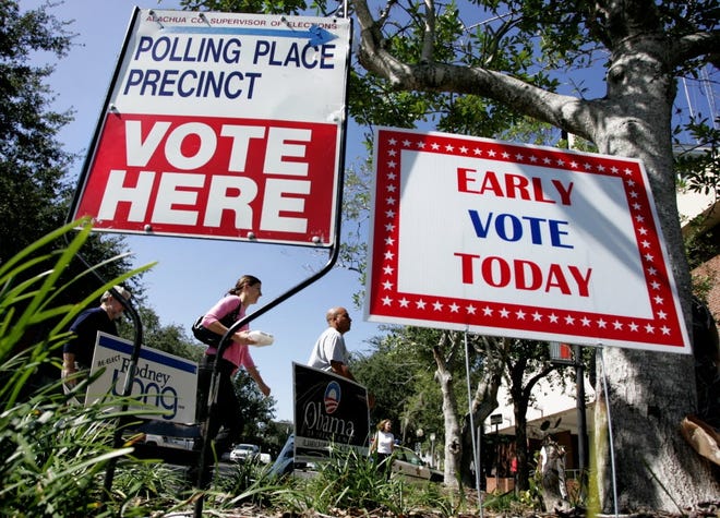 Pedestri­ans walk towards the Alachua County administration building for the first day of early voting for the 2008 general election. [File]