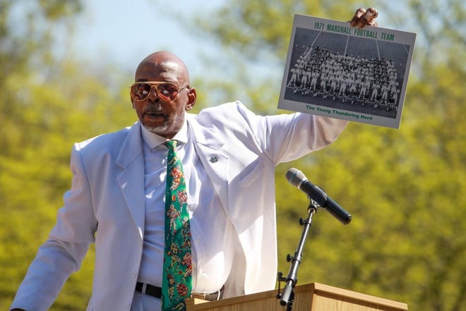 Former Marshall University quarterback Reggie Oliver holds up a photo of the 1971 Thundering Herd football teamn April 28 during Green and White Day in in Huntington, West Virginia. [Photo by The Herald-Dispatch]