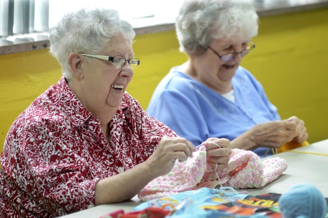 Eve Pauletich, left, of New Brighton and Annette Debelak of Beaver Falls crochet and knit garments, respectively, that will be donated to nursing homes, hospitals and children's advocacy groups in Beaver County and Ohio. They are members of Gwen Craig's Care Wear Angels, a volunteer group that meets twice a month at New Brighton United Methodist Church. [Lucy Schaly/BCT staff]
