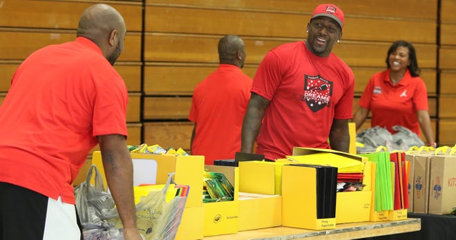 Carolinas Panthers linebacker Thomas Davis helps distributes school supplies to fill the 250 bookbags that were given out free to school kids Saturday afternoon at the Phillips Center on Echo Lane in Gastonia. [Mike Hensdill/The Gaston Gazette]