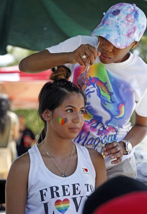 Dede Reid, with Wade Gordon Hairdressing Academy, puts glitter in the hair of Nautia Sanchez, from Lubbock, during the Lubbock Pride Festival, Saturday, Aug. 25, 2018, in Lubbock, Texas. [Brad Tollefson/A-J Media]