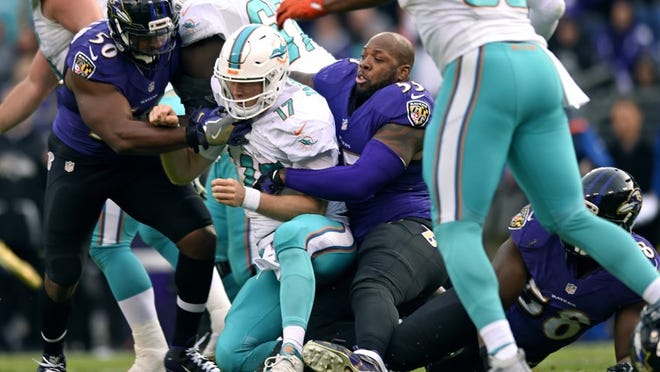 Baltimore Ravens outside linebacker Terrell Suggs (55) tackles Miami Dolphins quarterback Ryan Tannehill after his helmet fell off in the second half of an NFL football game, Sunday, Dec. 4, 2016, in Baltimore. (AP Photo/Gail Burton)