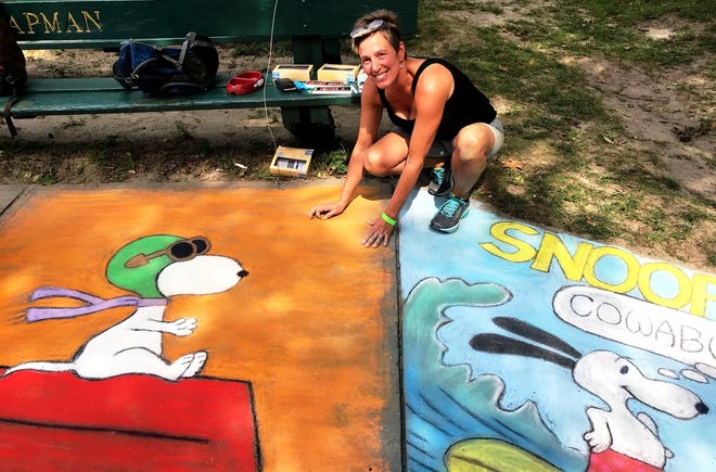 Lynn Peterson of West Wareham with her Snoopy-inspired street paintings on Saturday - one for her friend who is a pilot and one for her because, “it’s about the beach.”

[Wicked Local Photo/Mary McKenzie]